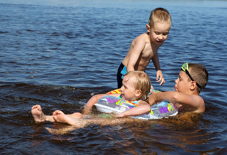 Bild på tre barn som badar